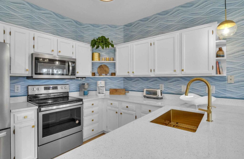 dwelling-place-interiors-brunswick-county-should-you-gut-or-refresh-your-kitchen-coastal-kitchen-unique-backsplash-white-and-blue-colors-updated-hardware